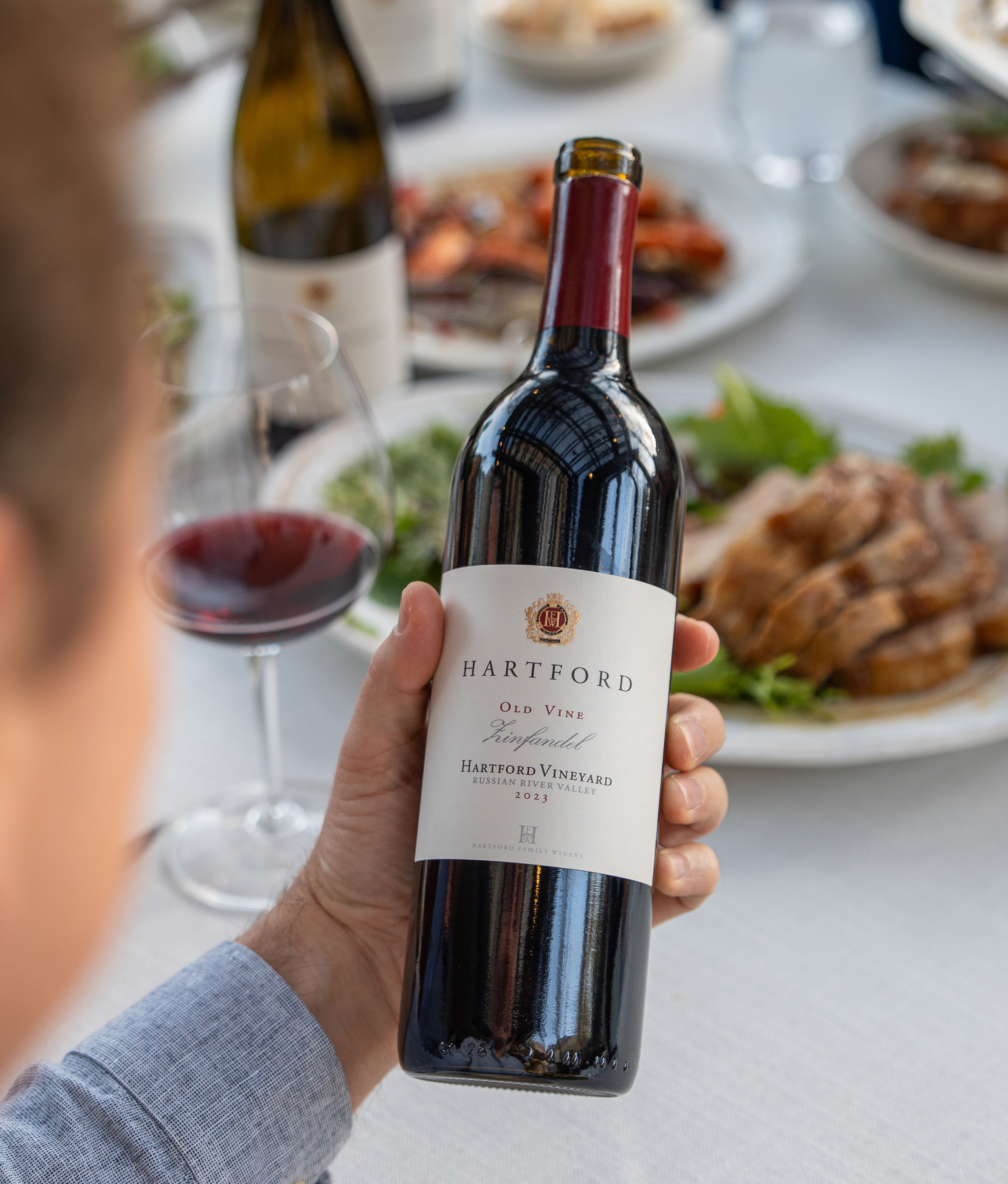 A person holding a bottle of Hartford red wine